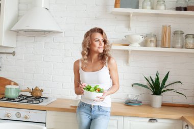 Evde sebze salatalı tatlı bir kadın var.