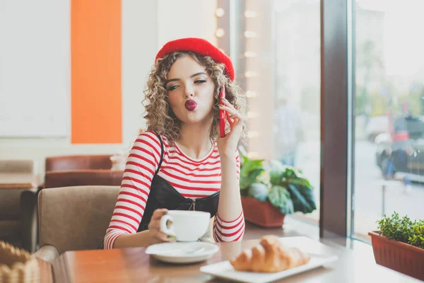 Фотография Красивой Молодой Женщины Сидящей Пьющей Кофе Кафе Держа Смартфон — стоковое фото