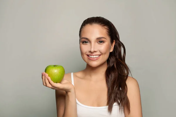 緑のリンゴを食べる陽気な若い女性の肖像画 — ストック写真