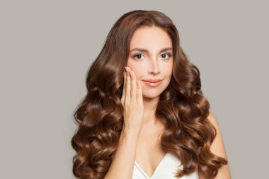 Uzun kahverengi dalgalı saçlı çekici bir kadın model. Kıvırcık saçlı güzel bir kadın. .