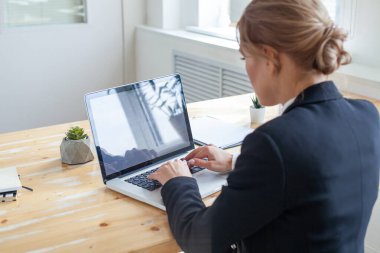 Arkadan bak. İş kadını dizüstü bilgisayarda e-posta, toplantıda sunum hazırlığı, internet bankacılığı için bilgi edinme veya işleme için daktilo ediyor