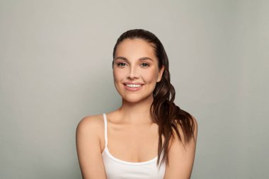 Sağlıklı, berrak ciltli, gülümseyen genç, güzel bir spa modeli. Yüz bakımı, cilt bakımı, kozmetoloji, güzellik ve kaplıca konsepti.