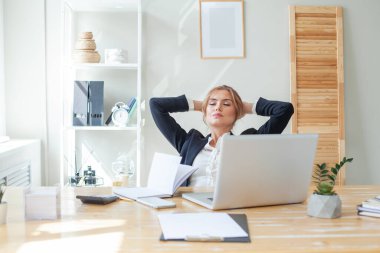 İş kadını işyerinde dinleniyor.