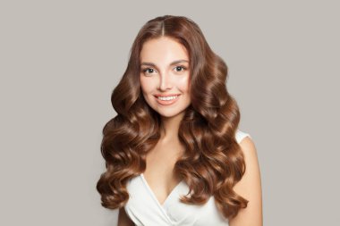 Attractive woman with long and shiny curly hair . Beautiful model woman with curly hairstyle. Care and beauty of hair concept