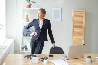 Happy young business woman posing in office