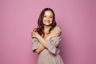 Gülümseyen ve kameraya bakan neşeli, genç bir kadın neşeli ve büyüleyici bir gülümsemeyle. 