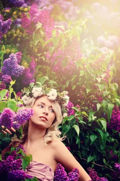 健康的皮肤和波浪的金发上淡紫色的花的漂亮女人的户外肖像 — 图库照片