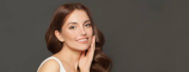 Temiz ciltli güzel bir kadın yüzü, Gri pankartta yakın plan portresi