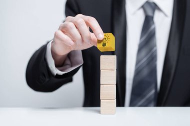 Businessman building business with ideas cube with light bulb. Business idea mockup. 