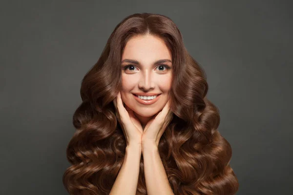年轻而快乐的女人 皮肤清澈 卷曲的头发 在灰色的背景上微笑着 护发和护肤概念 — 图库照片