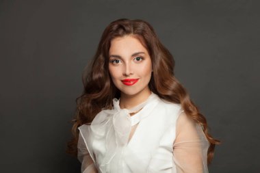 Brunette woman smiling on black background