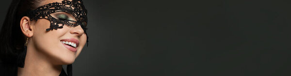 Крупный план портрета идеальной женщины в карнавальной маске на фоне черного баннера