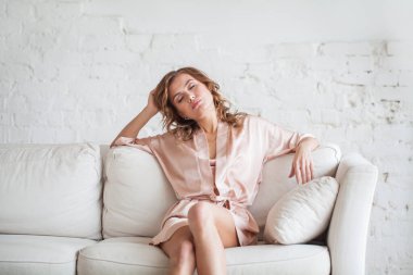 Tired woman relaxing on a sofa after work at home