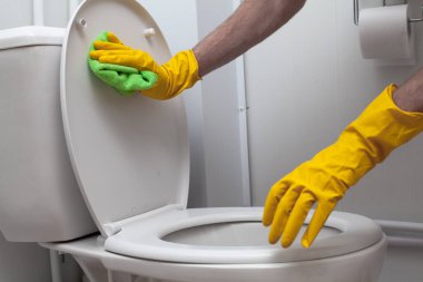 Man cleaning a white WC closeup