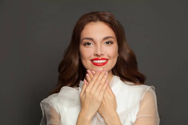 Perfect smiling model woman with curly hairstyle showing hands with pink manicure