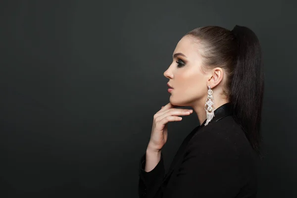 Perfect female profile on black background. Beautiful woman in diamond earring