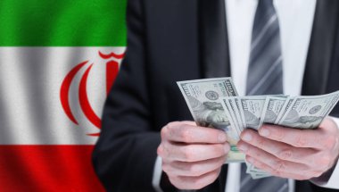 Hands holding dollar money on flag of Iran