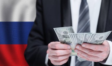 Hands holding dollar money on flag of Russia