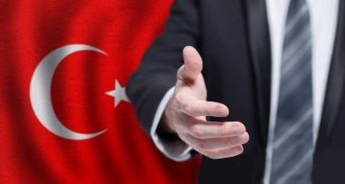 Turkish business, politics, cooperation and travel concept. Hand on flag of Turkey background.