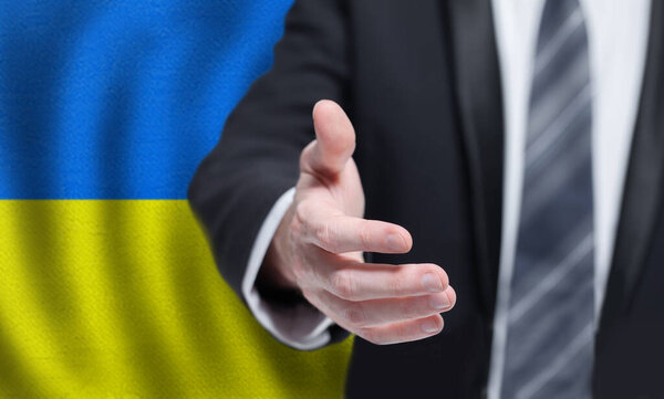 Украинский бизнес, политика, сотрудничество и туристическая концепция. Рука на фоне флага Украины.