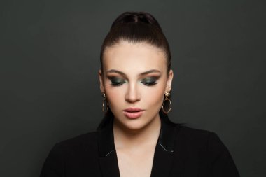 Beautiful fashion model woman face with dark green smokey eyes makeup closeup portrait