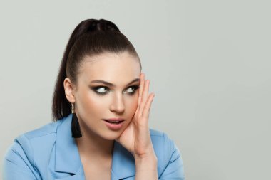 Pretty model woman brunette looking aside at copy space on gray background