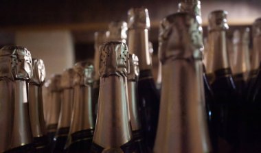 Many bottles of champagne on blurred background closeup