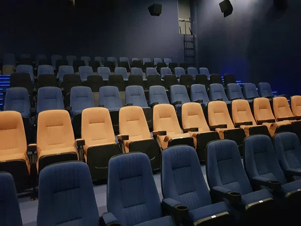 Empty row line of blue and orange seats in the cinema hall