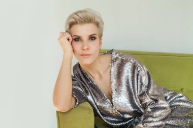 Oturma odasındaki kanepesinde dinlenen hoş bir kadın. Evdeki kanepede oturan güzel bir kadının portresi.