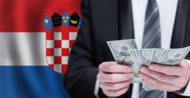 Hands holding dollar money on flag of Croatia