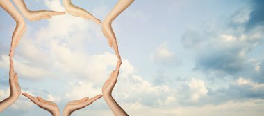 Unity concept. Hands against sky clouds background