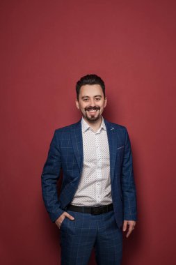Smiling friendly professional man on red background portrait