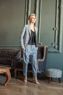 Mavi takım elbiseli, gülen bir kadın.