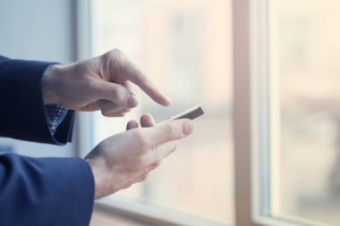 Close up view of young professional businessman using smartphone