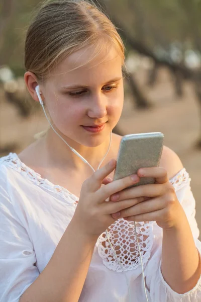 Gülümseyen Güzel Kız Dışarıda Yürüyor Kulaklıkla Müzik Dinliyor Cep Telefonu — Stok fotoğraf