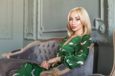 Stylish beautiful cute woman sitting in grey interior