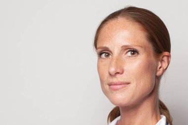 Natural beauty. Portrait of middle-aged woman with freckles closeup