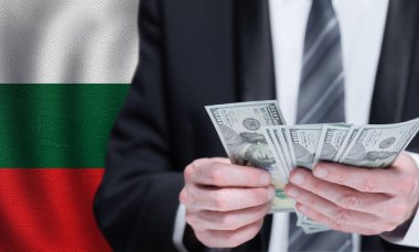 Hands holding dollar money on flag of Bulgaria