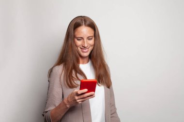 Cheerful friendly woman messaging, browsing internet, using smartphone and shopping on white background