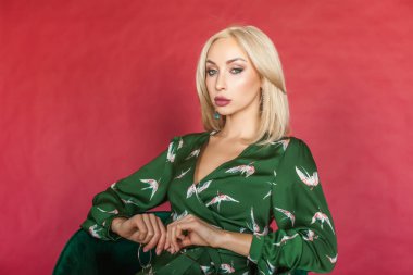 Fashion portrait of young elegant woman on red background