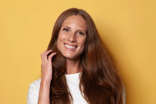 Portrait Beautiful Smiling Mature Woman Long Brown Hair Yellow Background — Zdjęcie stockowe