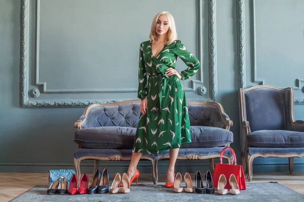 Happy young woman surrounded by her shoes