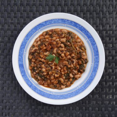 Domates soslu bezelye, ıspanak ve diğer sebzeler. Mavromatika fasolisi Yunan yemeği.