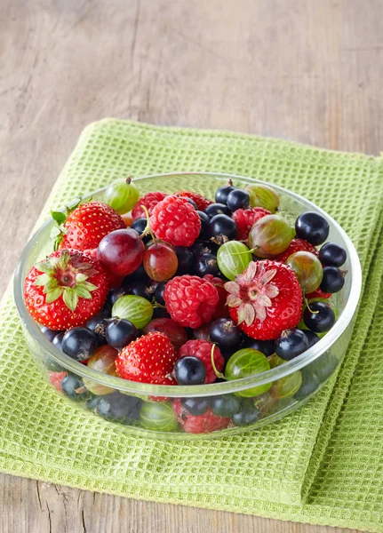 Schüssel mit frischen reifen Beeren auf grünem Tischtuch — Stockfoto