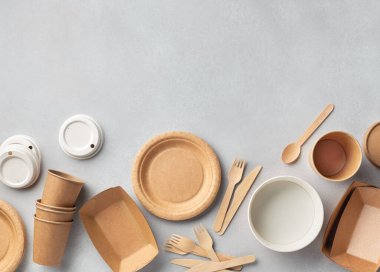 Çeşitli karton ya da el işi kağıtları gri arka plan, üst görüş, çevre dostu tek kullanımlık tabak, kase, bardak ve çatal bıçak seti üzerindeki yiyecek kutularını kaldırır. Geri dönüşüm kavramı