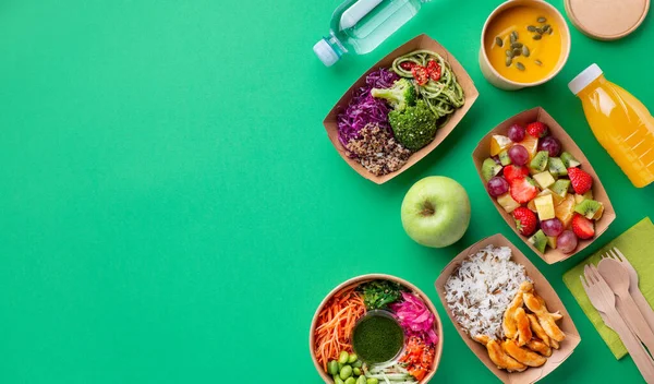 健康地把食物和饮料放在绿色背景的一次性环保纸盒中 尽收眼底 每日新鲜食物 水瓶及果汁 — 图库照片