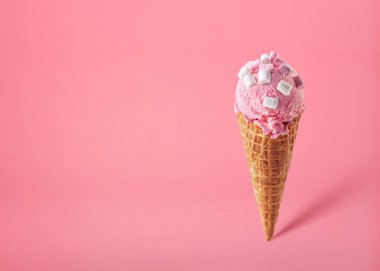 Pembe arka planda marshmallowlu pembe çilekli dondurma külahı. Metin için boşluk.