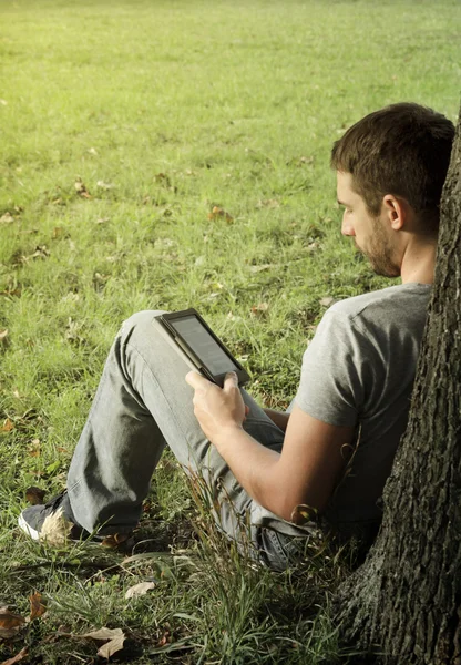 Jovem lendo e-book — Fotografia de Stock