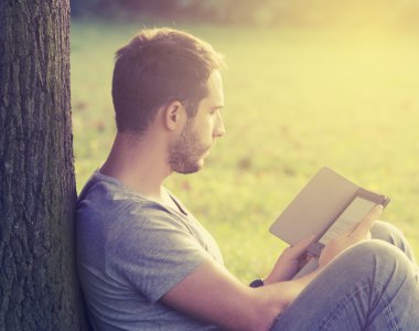 Young man reading e-book clipart