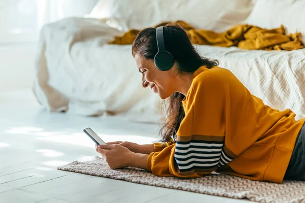 Šťastná Žena Neformálním Žlutém Oblečení Ležící Podlaze Používající Telefon Pro — Stock fotografie